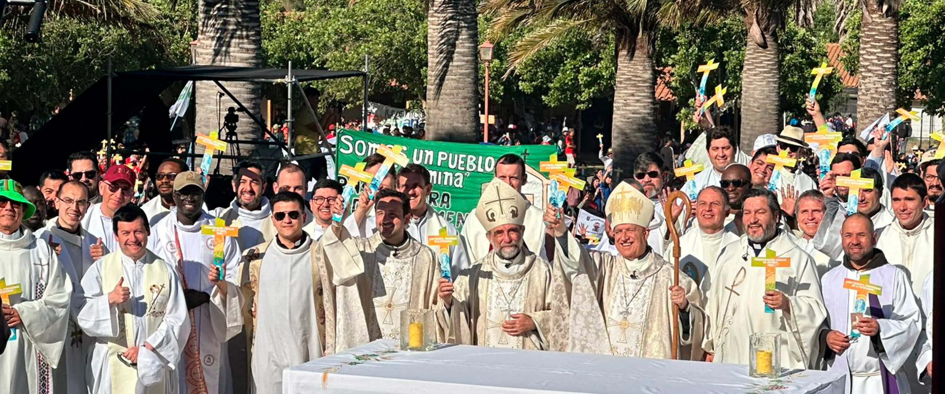 Obispos y sacerdotes concelebran la eucaristía al aire libre entre palmeras